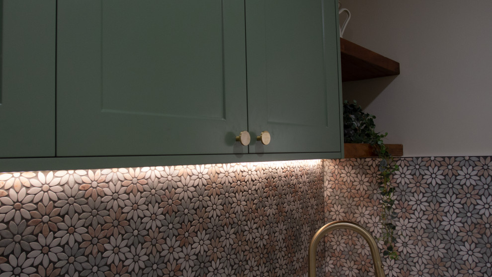 Photo of a small contemporary single-wall utility room in Gold Coast - Tweed with a belfast sink, shaker cabinets, green cabinets, concrete worktops, mosaic tiled splashback, beige walls, dark hardwood flooring, a side by side washer and dryer, brown floors and grey worktops.