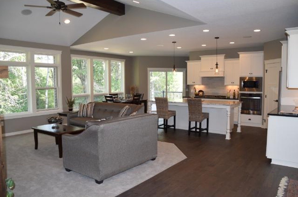 Inspiration for a mid-sized transitional l-shaped dark wood floor open concept kitchen remodel in Minneapolis with shaker cabinets, white cabinets, granite countertops, stainless steel appliances, an island, a double-bowl sink, beige backsplash and stone slab backsplash