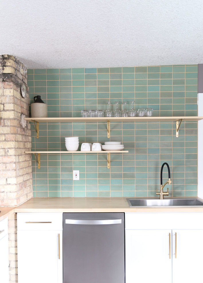 Inspiration for a small transitional l-shaped light wood floor and brown floor open concept kitchen remodel in Minneapolis with a drop-in sink, flat-panel cabinets, white cabinets, wood countertops, green backsplash, ceramic backsplash, stainless steel appliances, no island and brown countertops