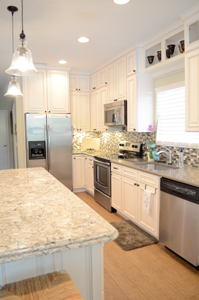Inspiration for a mid-sized beach style single-wall open plan kitchen in Jacksonville with an undermount sink, raised-panel cabinets, beige cabinets, quartzite benchtops, stainless steel appliances, porcelain floors and with island.