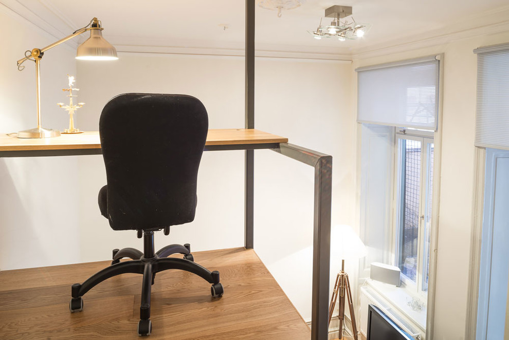 Bild på ett litet funkis hemmastudio, med vita väggar, mellanmörkt trägolv och ett inbyggt skrivbord