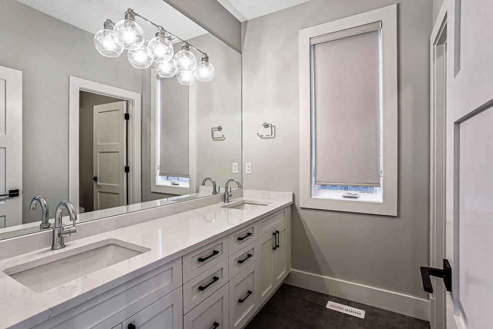 Inspiration for a transitional kids' white tile and ceramic tile ceramic tile, multicolored floor and double-sink corner shower remodel in Calgary with shaker cabinets, white cabinets, a two-piece toilet, gray walls, an undermount sink, quartz countertops, a hinged shower door, white countertops and a built-in vanity