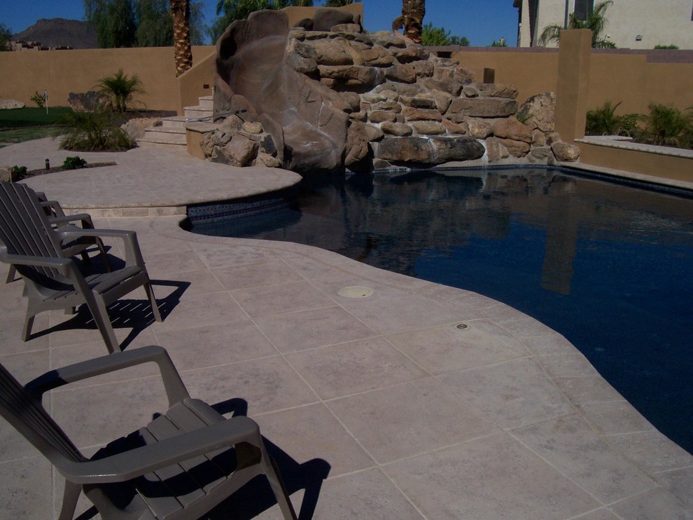 Large tuscan backyard concrete paver pool photo in Phoenix