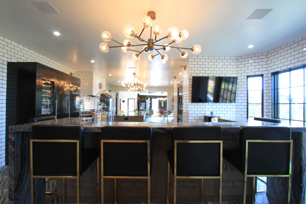 Inspiration for a huge eclectic l-shaped ceramic tile enclosed kitchen remodel in Orange County with an undermount sink, flat-panel cabinets, gray cabinets, marble countertops, white backsplash, subway tile backsplash, black appliances and an island