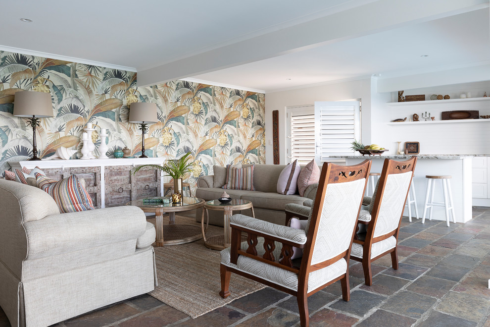 This is an example of a tropical open concept living room in Brisbane with beige walls and grey floor.