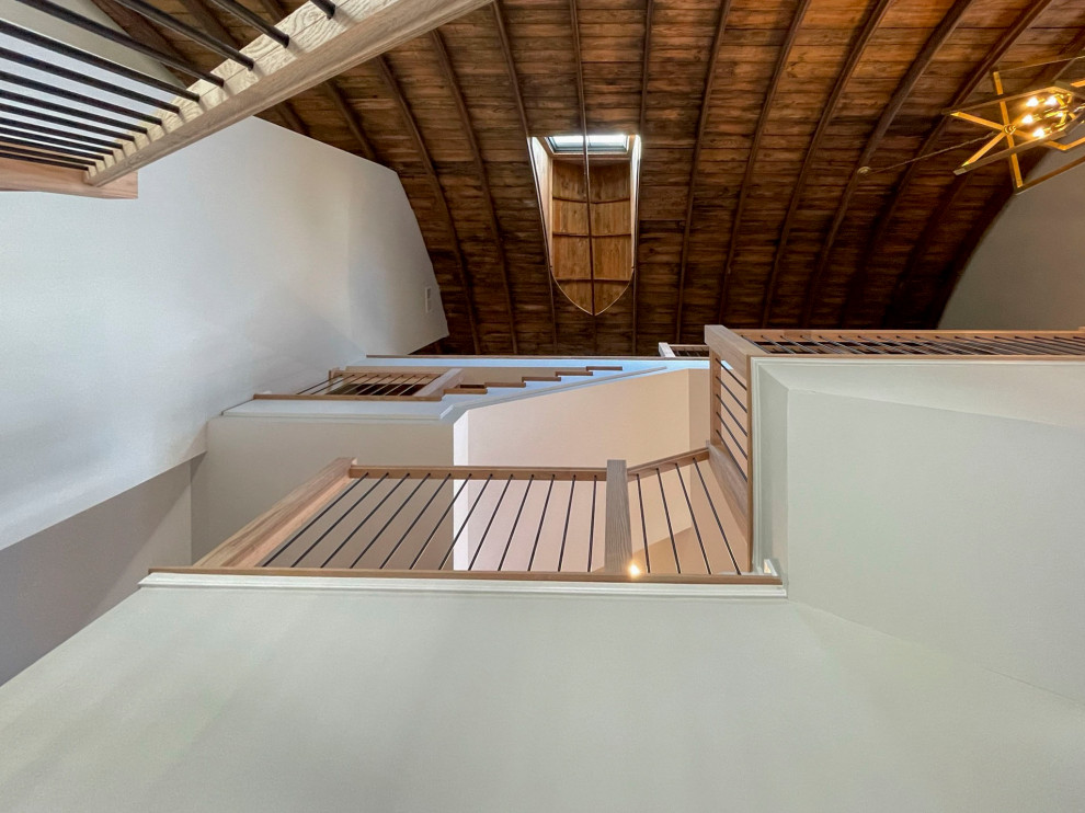 Imagen de escalera recta clásica renovada extra grande con escalones de madera, contrahuellas de madera y barandilla de varios materiales