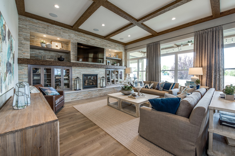 Large traditional open concept family room in Salt Lake City with grey walls, light hardwood floors, a standard fireplace, a stone fireplace surround, a wall-mounted tv and brown floor.