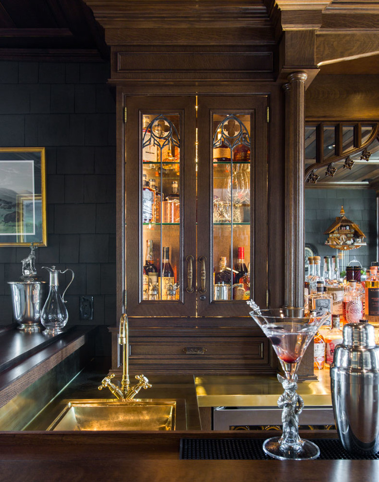 This is an example of a large traditional l-shaped seated home bar in St Louis with a drop-in sink, beaded inset cabinets, medium wood cabinets, copper benchtops, multi-coloured splashback and porcelain floors.