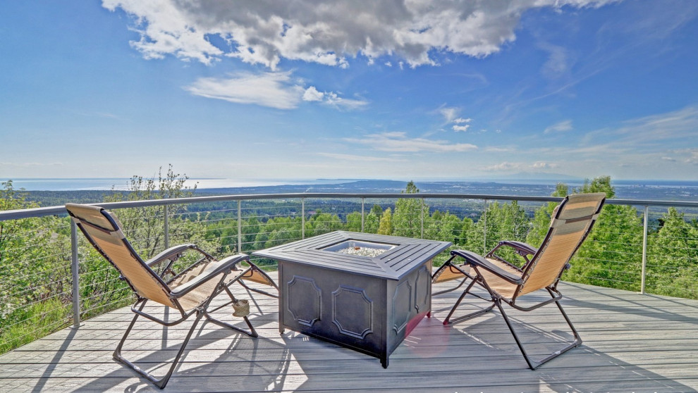 Inspiration for a large side yard ground level cable railing deck remodel with no cover
