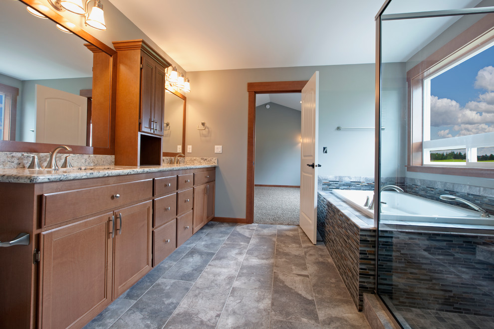 Mid-sized arts and crafts master bathroom in Seattle with an undermount sink, recessed-panel cabinets, medium wood cabinets, granite benchtops, a drop-in tub, a one-piece toilet, gray tile, ceramic tile, grey walls and ceramic floors.