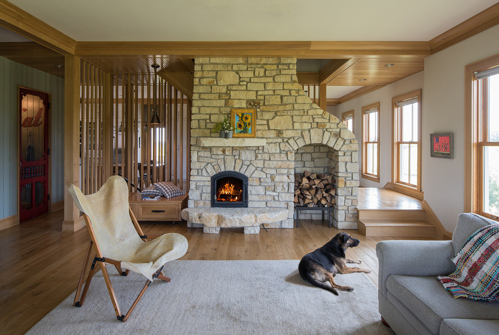 Photo of a country living room in Minneapolis with white walls, medium hardwood floors and a standard fireplace.