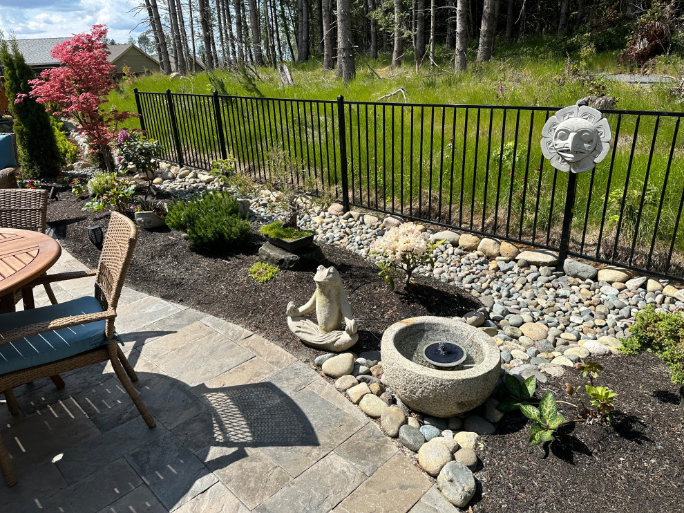 Réalisation d'un petit jardin arrière bohème avec des pavés en béton et une clôture en métal.