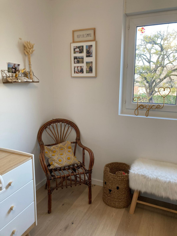 На фото: нейтральная комната для малыша среднего размера в скандинавском стиле с белыми стенами, светлым паркетным полом и бежевым полом