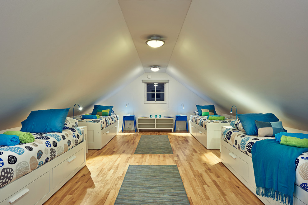 Photo of an expansive transitional kids' bedroom for kids 4-10 years old and boys in London with white walls and light hardwood floors.