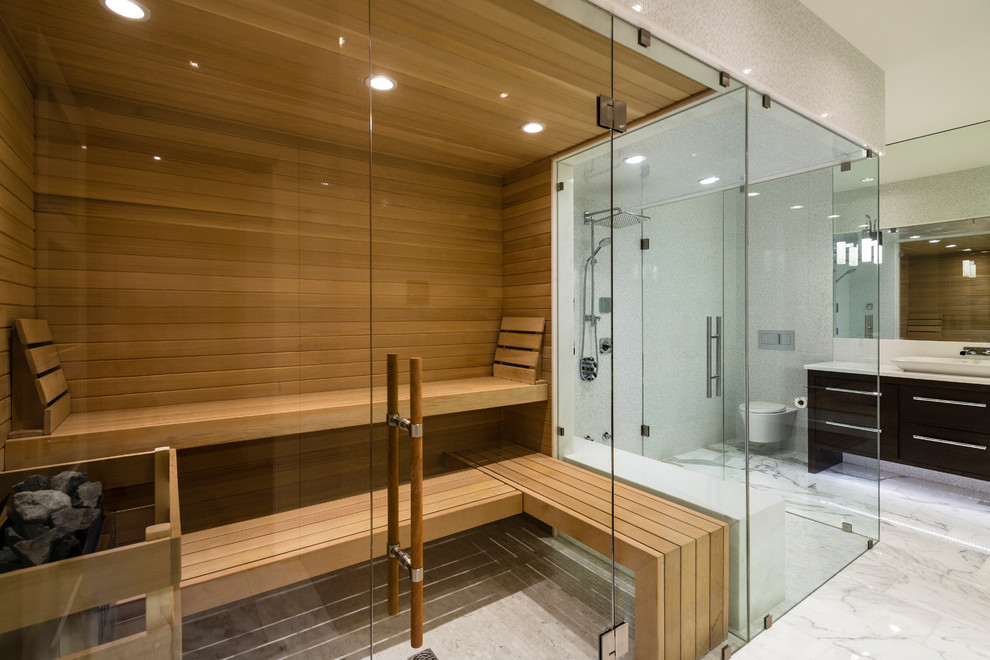 Inspiration for a large contemporary bathroom in Vancouver with flat-panel cabinets, dark wood cabinets, an open shower, a wall-mount toilet, multi-coloured tile, porcelain tile, multi-coloured walls, marble floors, with a sauna, a vessel sink, engineered quartz benchtops, white floor and a hinged shower door.