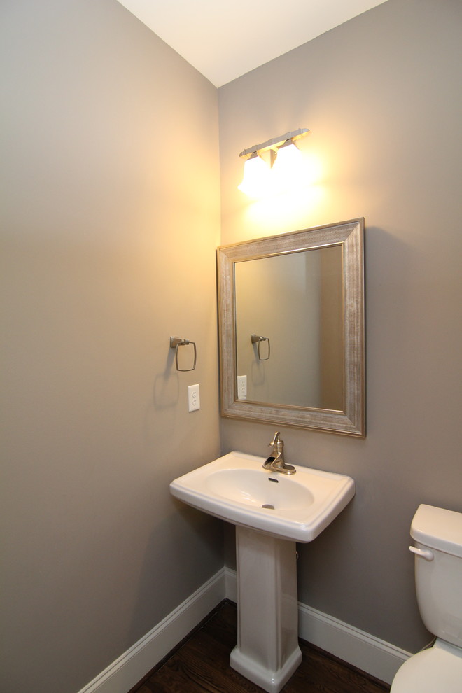 Kleine Klassische Gästetoilette mit Toilette mit Aufsatzspülkasten, grauer Wandfarbe, braunem Holzboden und Sockelwaschbecken in Raleigh