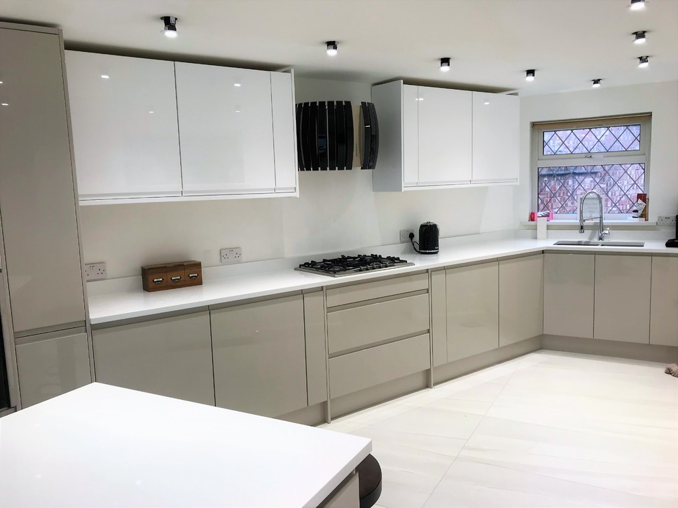 Photo of a mid-sized modern l-shaped eat-in kitchen in London with flat-panel cabinets, with island and white floor.