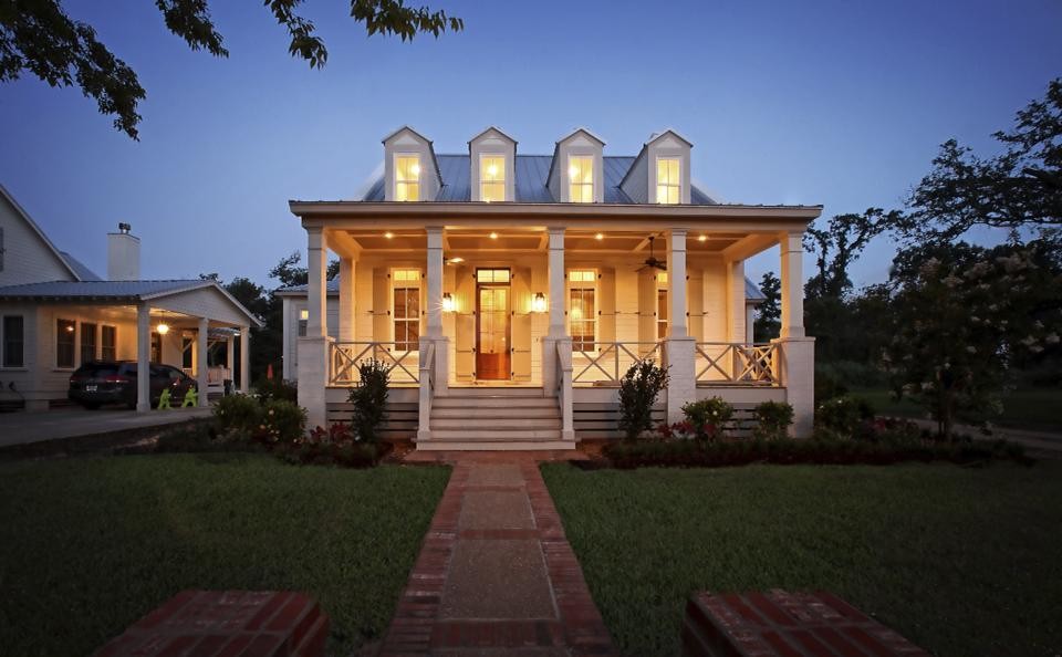 Inspiration for a mid-sized traditional two-storey white house exterior in New Orleans with wood siding, a hip roof and a metal roof.