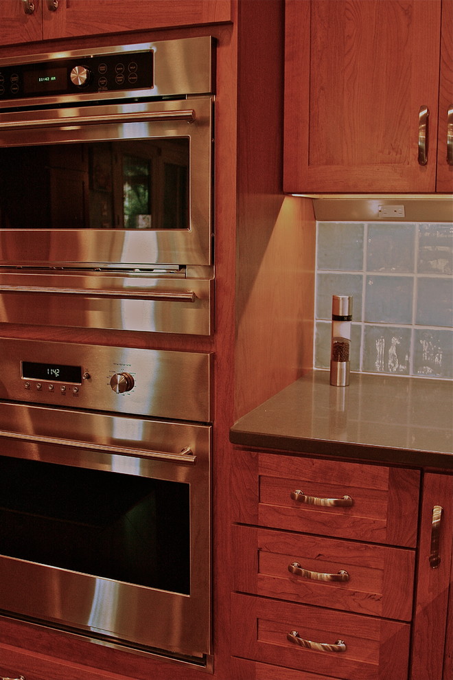 Example of a transitional laminate floor kitchen design in DC Metro with shaker cabinets, quartz countertops, blue backsplash and porcelain backsplash