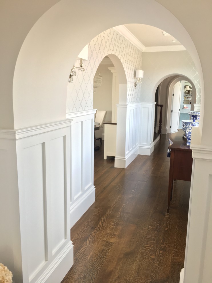 Inspiration for a large beach style hallway in Providence with white walls and dark hardwood floors.