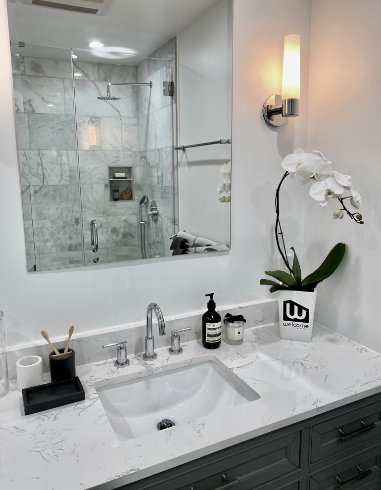 Photo of a mid-sized traditional master bathroom in Los Angeles with furniture-like cabinets, grey cabinets, an alcove tub, a corner shower, a one-piece toilet, white tile, marble, white walls, marble floors, an undermount sink, engineered quartz benchtops, white floor, a hinged shower door, white benchtops, a niche, a single vanity and a freestanding vanity.