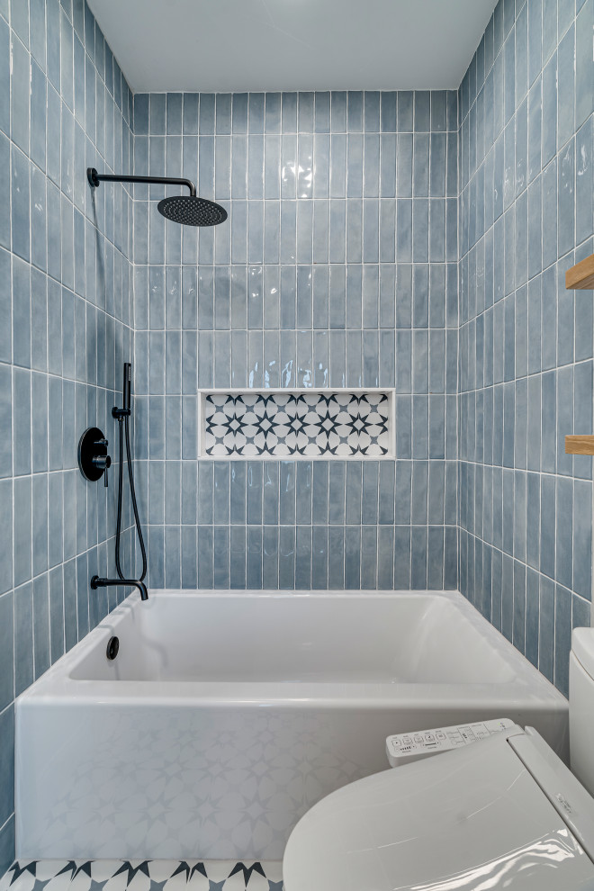 Inspiration for a small kids' blue tile ceramic tile and single-sink drop-in bathtub remodel in DC Metro with flat-panel cabinets, light wood cabinets, a two-piece toilet, white walls, an undermount sink and a freestanding vanity