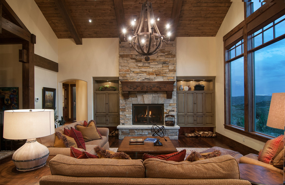 Country living room in Salt Lake City with beige walls, a standard fireplace and a stone fireplace surround.