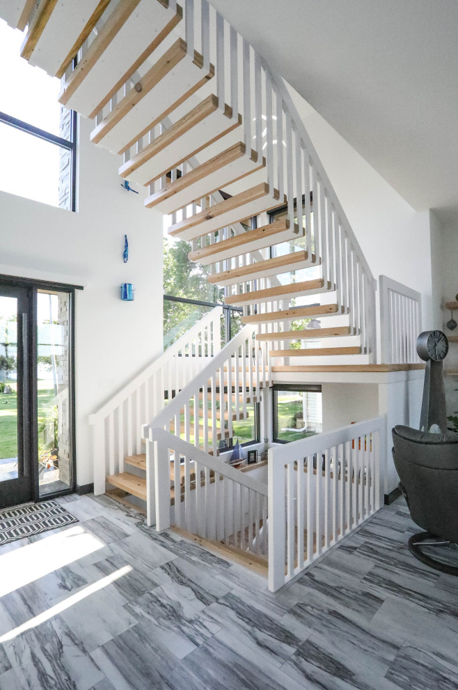 Design ideas for an expansive modern wood floating staircase in Other with metal railing.