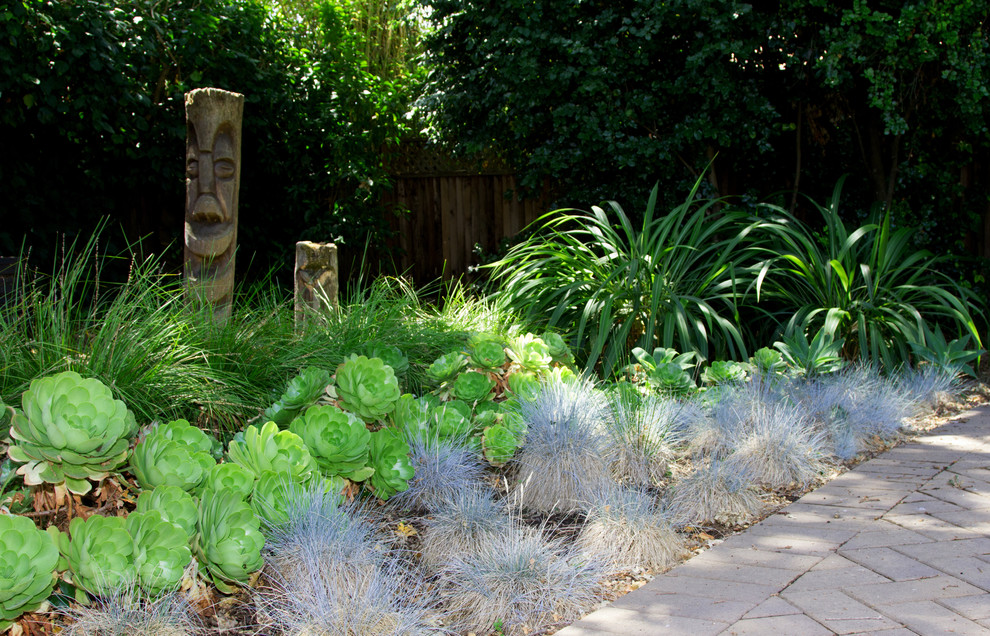 Diseño de jardín ecléctico de tamaño medio en patio trasero con jardín francés y exposición parcial al sol