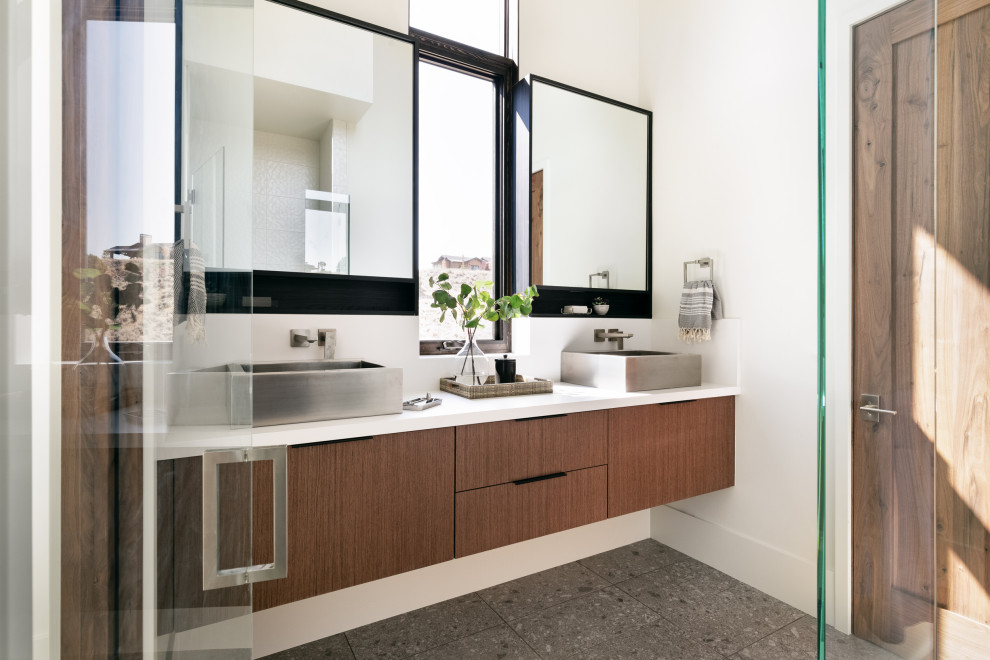 This is an example of a contemporary master bathroom in Salt Lake City with flat-panel cabinets, brown cabinets, white walls, a vessel sink, grey floor, white benchtops, a double vanity and a floating vanity.