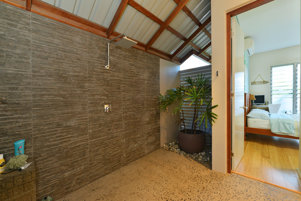 This is an example of a tropical 3/4 bathroom in Cairns with a curbless shower, gray tile, concrete floors, grey floor and an open shower.