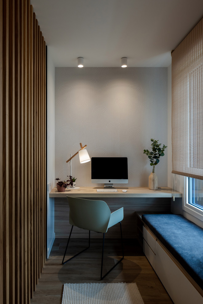 Idée de décoration pour un bureau design de taille moyenne et de type studio avec un mur gris, un sol en bois brun, un bureau intégré et du papier peint.
