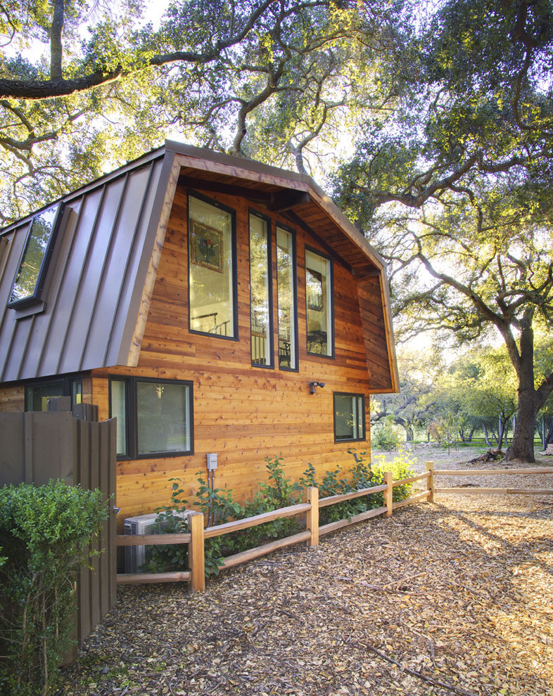 Photo of a contemporary exterior in Los Angeles with wood siding and a gambrel roof.