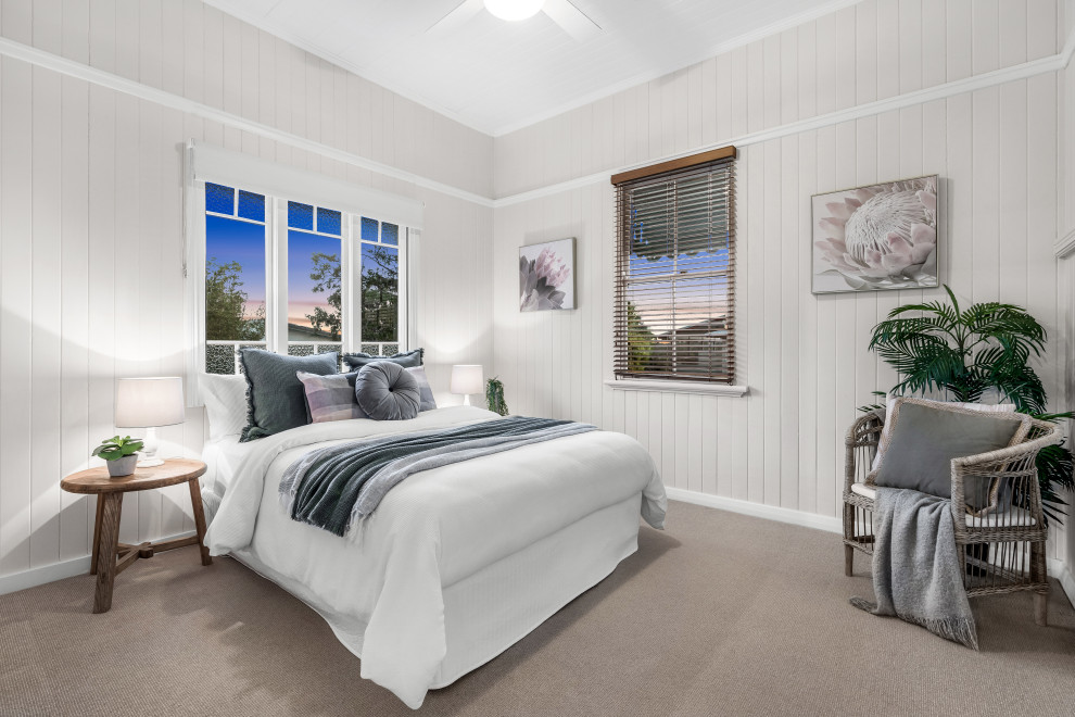 Design ideas for a beach style bedroom in Brisbane with planked wall panelling and timber.