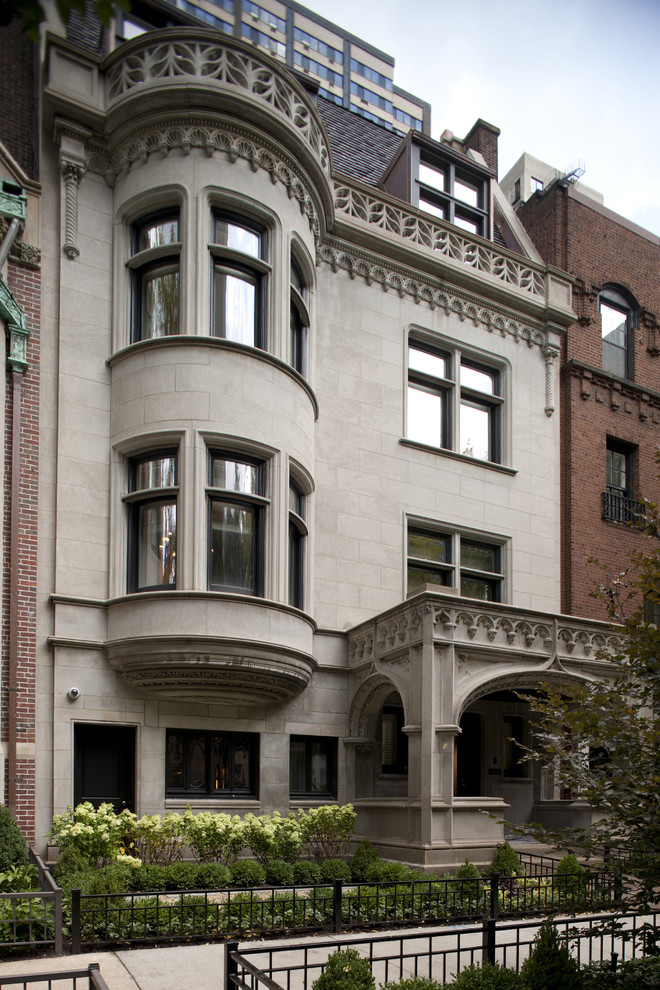 Large traditional three-storey grey exterior in Chicago with stone veneer.