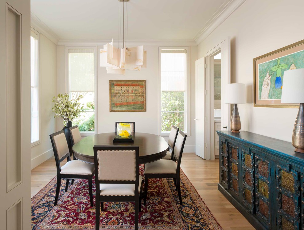 This is an example of a transitional separate dining room in Dallas with white walls and light hardwood floors.