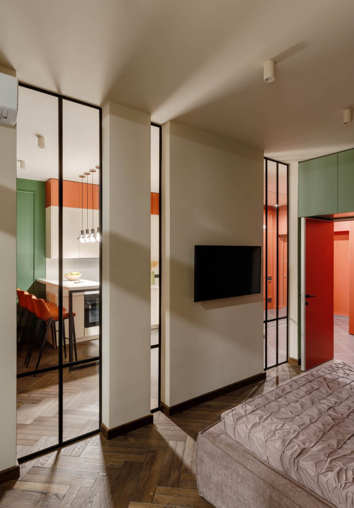 На фото: хозяйская спальня среднего размера в современном стиле с оранжевыми стенами, паркетным полом среднего тона, коричневым полом и акцентной стеной без камина