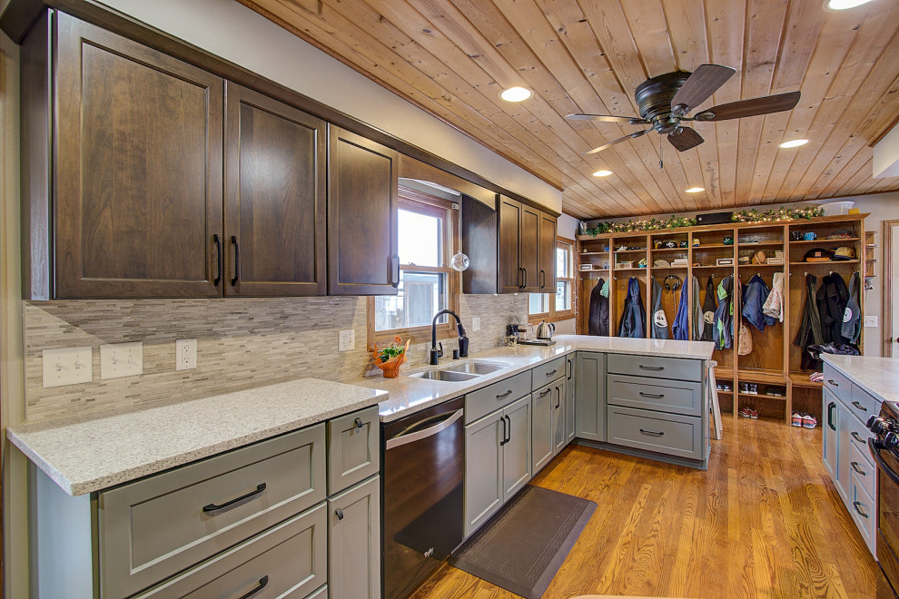 Eat-in kitchen - mid-sized transitional galley medium tone wood floor and brown floor eat-in kitchen idea with an undermount sink, shaker cabinets, gray cabinets, quartz countertops, gray backsplash, stone tile backsplash, black appliances, a peninsula and white countertops