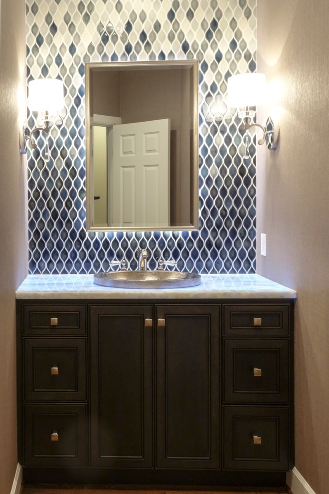 This is an example of a mid-sized transitional powder room in Seattle with a drop-in sink, dark wood cabinets, quartzite benchtops, a two-piece toilet, blue tile, ceramic tile, grey walls and recessed-panel cabinets.