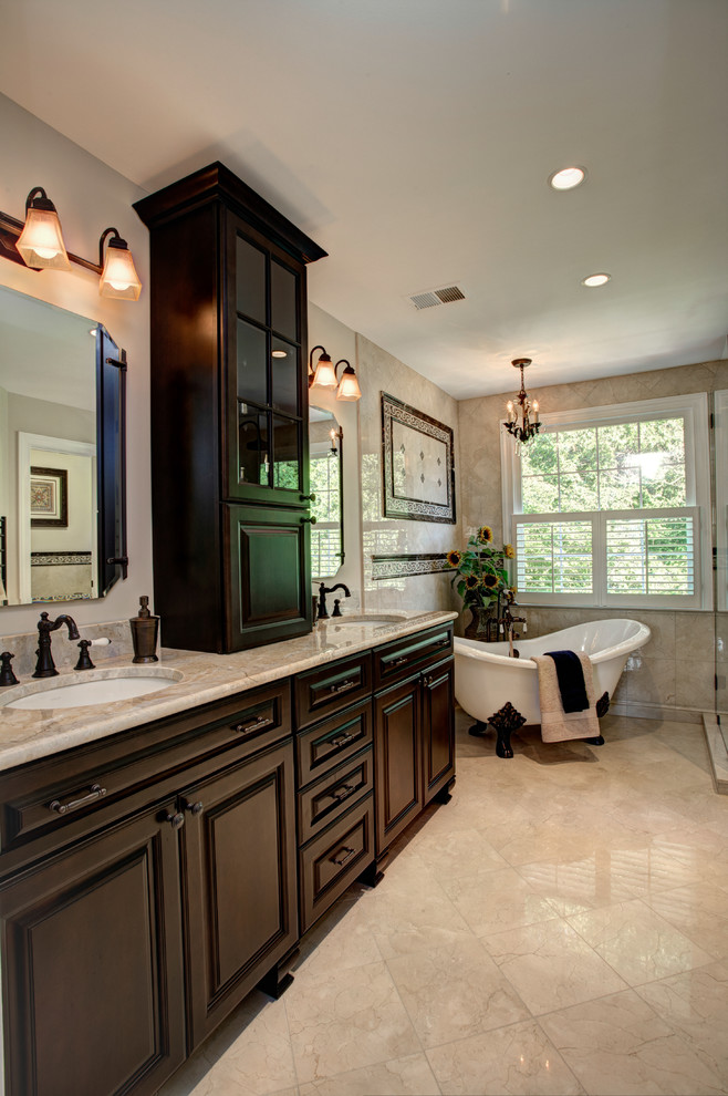 Mid-sized traditional master bathroom in DC Metro with raised-panel cabinets, dark wood cabinets, a claw-foot tub, a corner shower, beige tile, limestone, beige walls, limestone floors, an undermount sink and granite benchtops.