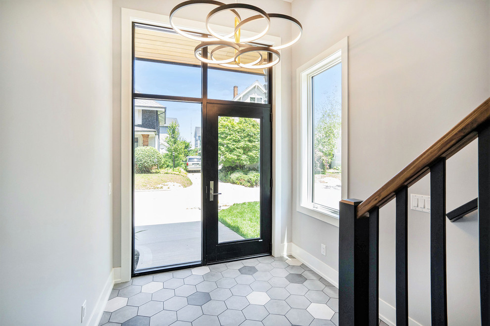 Photo of a mid-sized modern front door in Grand Rapids with grey walls, porcelain floors, a single front door, a black front door and multi-coloured floor.