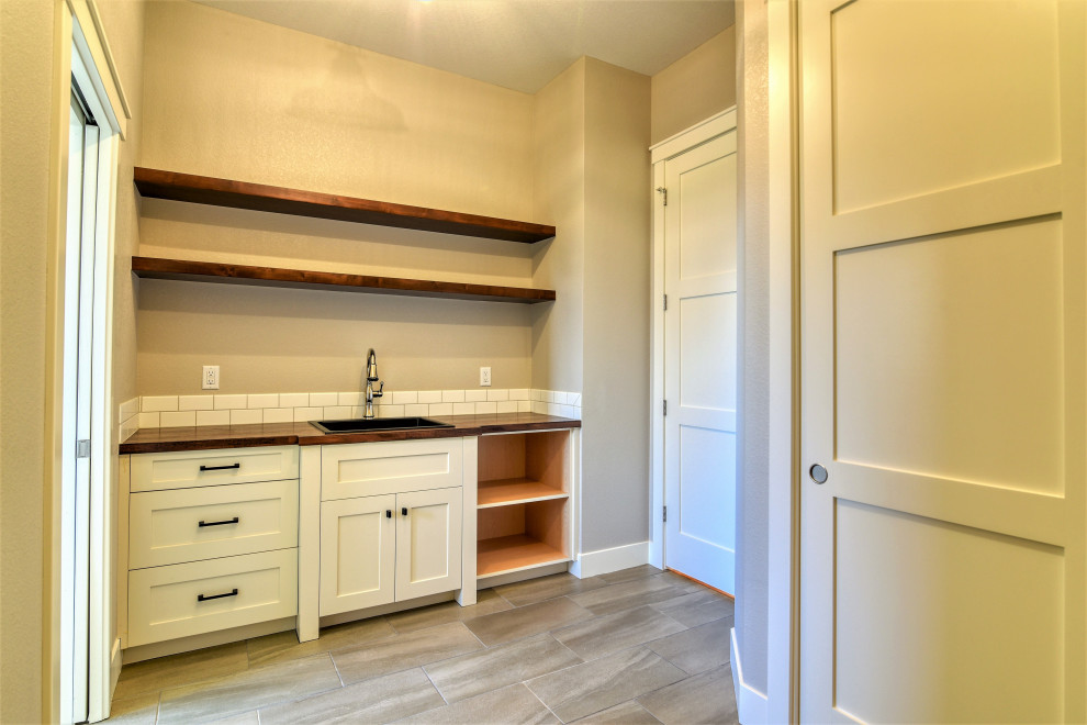 Design ideas for a mid-sized country mudroom in Denver with grey walls, porcelain floors and grey floor.