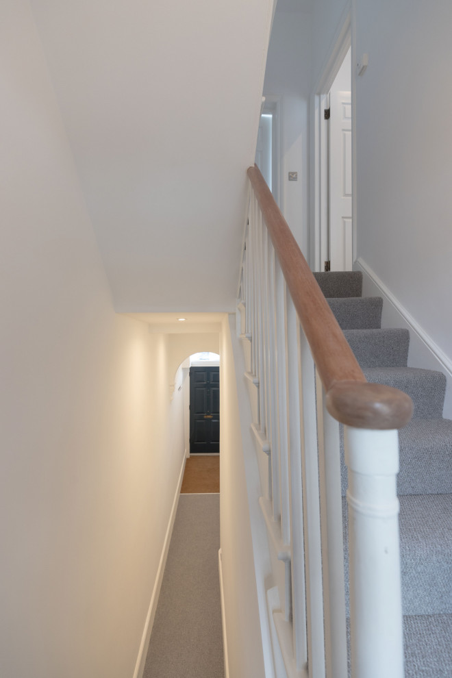 Design ideas for a mid-sized traditional hallway in London with white walls, carpet and grey floor.