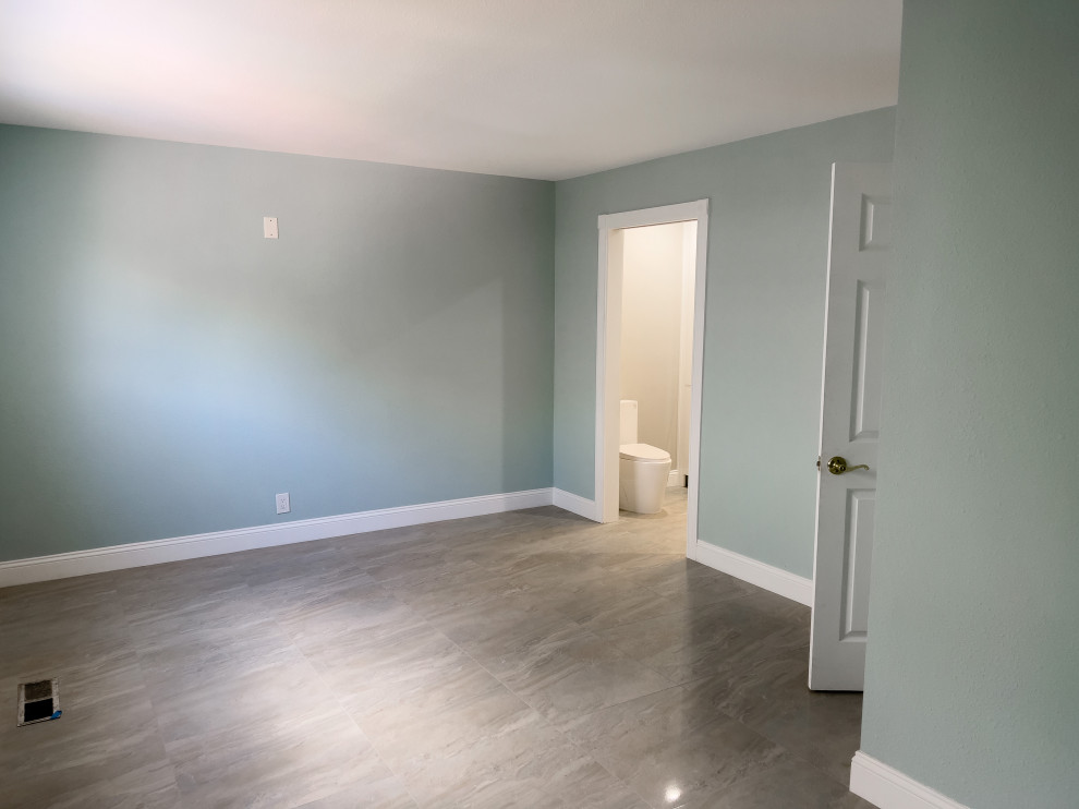 Aménagement d'une chambre parentale moderne de taille moyenne avec un mur bleu, un sol en carrelage de céramique et un sol gris.
