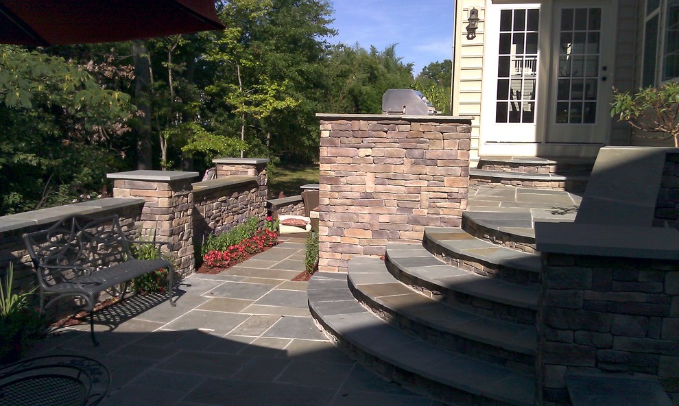 Large transitional backyard stone patio photo in DC Metro with a fire pit and no cover