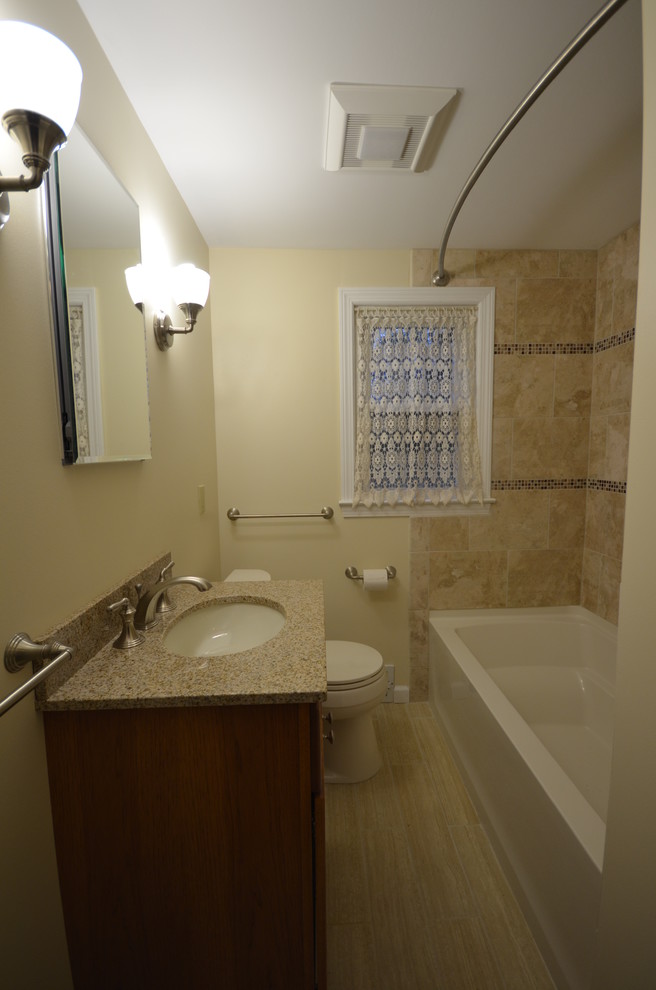 Design ideas for a small traditional bathroom in Other with an undermount sink, shaker cabinets, medium wood cabinets, granite benchtops, an alcove tub, a two-piece toilet, beige tile, cement tile, white walls and porcelain floors.