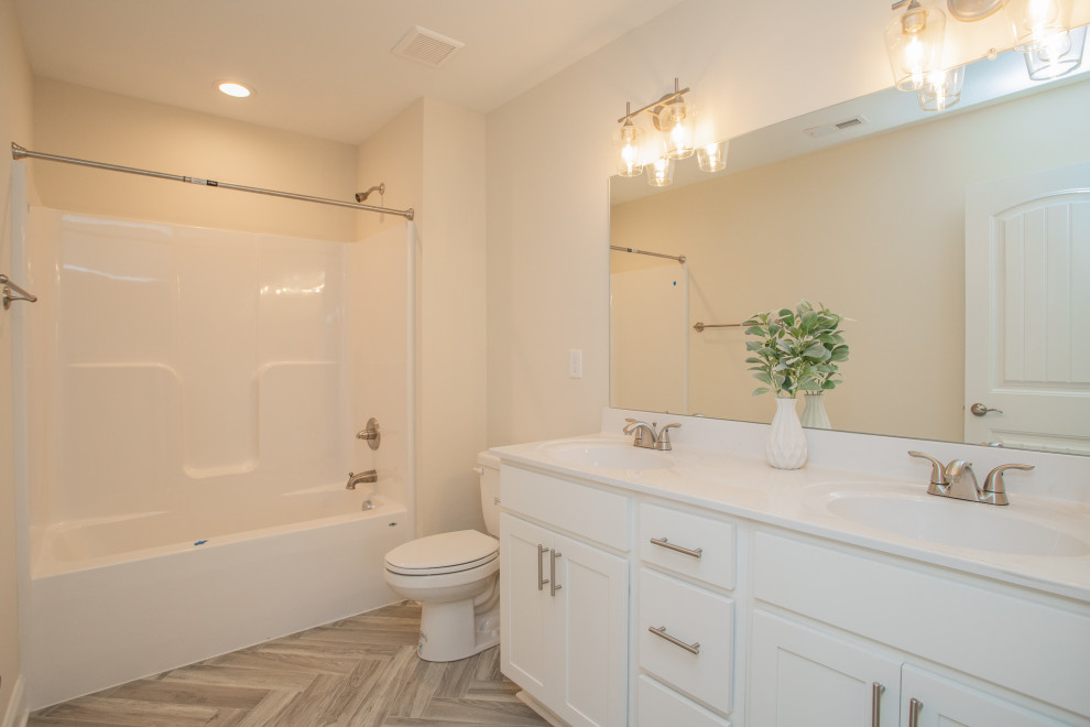 Design ideas for a large arts and crafts kids bathroom in Other with recessed-panel cabinets, white cabinets, a shower/bathtub combo, a two-piece toilet, beige walls, vinyl floors, an integrated sink, grey floor, a shower curtain, white benchtops, a double vanity and a built-in vanity.