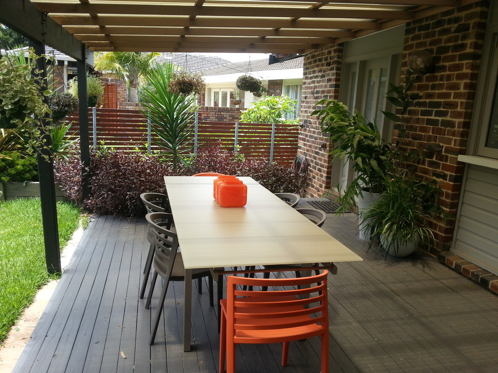 Mid-sized contemporary front yard verandah in Sydney with decking and an awning.