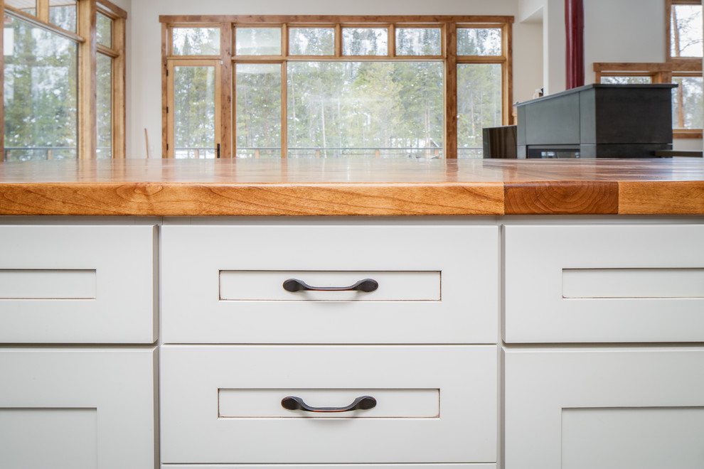 Mid-sized mountain style single-wall eat-in kitchen photo in Denver with an undermount sink, shaker cabinets, distressed cabinets, quartz countertops, blue backsplash, glass tile backsplash, stainless steel appliances, an island and gray countertops