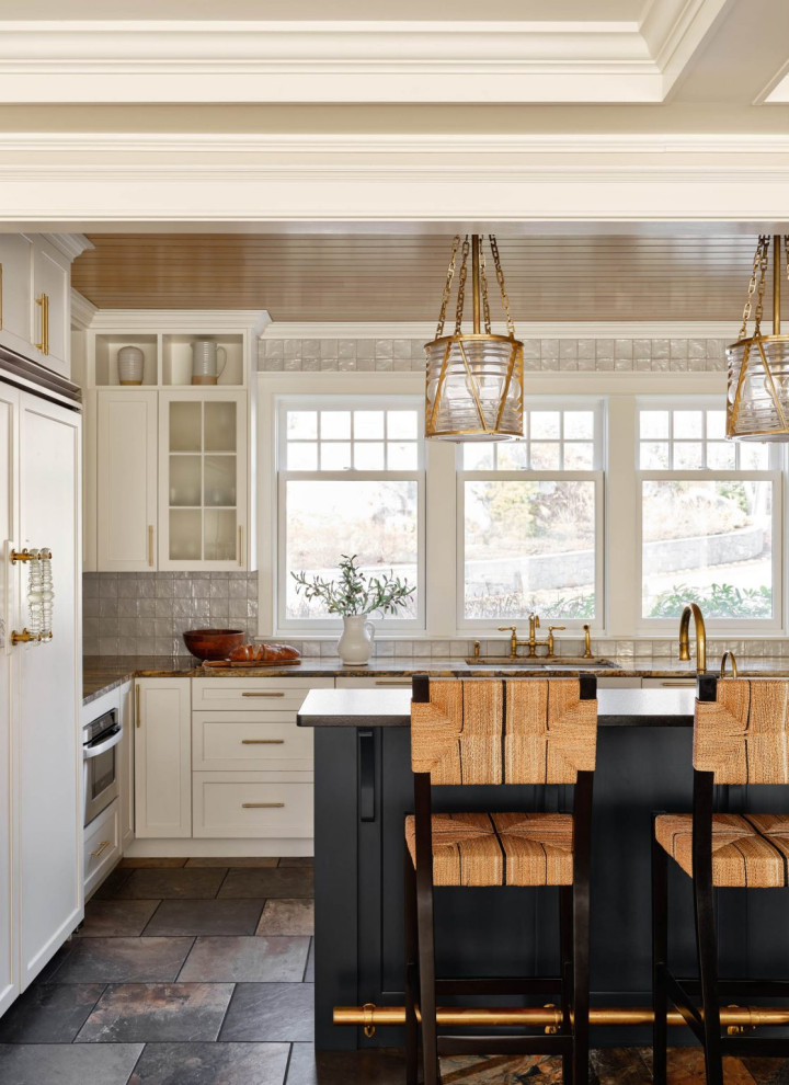 Photo of a beach style l-shaped kitchen in Boston with an undermount sink, shaker cabinets, white cabinets, white splashback, with island, brown floor, brown benchtop and wood.